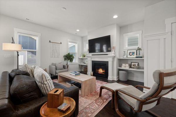 Salon cosy avec une cheminée et un tableau décoratif nature accroché au-dessus du manteau